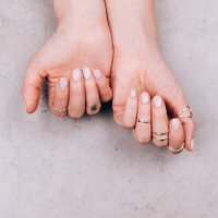 woman hands with nude pink manicure and with many various silver rings on fingers on concrete gray background. concept of trendy boho style. flat lay style with copy space - nails art stock pictures, royalty-free photos & ima