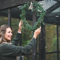 woman hangs a christmas wreath - garden decoration stock pictures, royalty-free photos & images