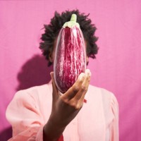 woman holding aubergine in front of face - food stock pictures, royalty-free photos & images