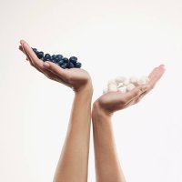 woman holding handful of blueberries over handful of sugar cubes - junk food stock pictures, royalty-free photos & images