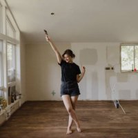 woman holding paintbrush and dancing in new home - home decoration stock pictures, royalty-free photos & images