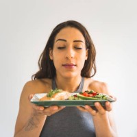 woman holding plate with vegetables and salmon - food stock pictures, royalty-free photos & images