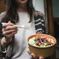 woman holding poke in a cardboard plate. - junk food stock pictures, royalty-free photos & images