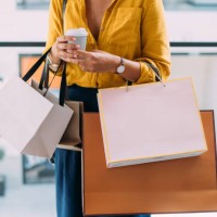 woman holding shopping bags and coffee in a mall - fashion stock pictures, royalty-free photos & images