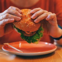 woman holding vegetarian plant based burger - junk food stock pictures, royalty-free photos & images