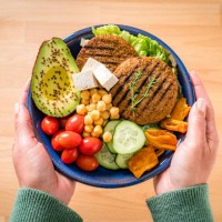 woman holds a plate with healty plant-based food - food stock pictures, royalty-free photos & images