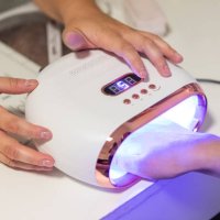 woman in nail salon receiving manicure by beautician - nails art stock pictures, royalty-free photos & images