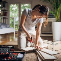 woman is assembling shelf at home - home decoration stock pictures, royalty-free photos & images
