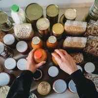 woman is rearranging the kitchen pantry - food stock pictures, royalty-free photos & images