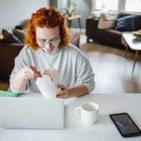 woman is taking a lunch break while working from home - junk food stock pictures, royalty-free photos & images