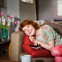 woman laughing while watching tv. - home decoration stock pictures, royalty-free photos & images