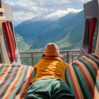 woman laying in camper van overlooking furka pass in switzerland - travel stock pictures, royalty-free photos & images