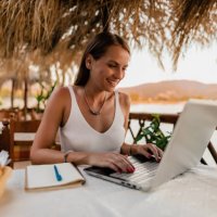 woman learning and using a laptop in a restaurant at the seaside - travel stock pictures, royalty-free photos & images