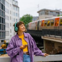 woman listening to music in headphones on the background of subway in hamburg - travel stock pictures, royalty-free photos & images