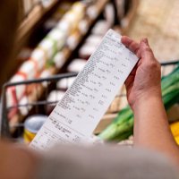 woman looking at a receipt after shopping at the supermarket - food stock pictures, royalty-free photos & images