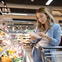 woman looking at shopping list in store - food stock pictures, royalty-free photos & images