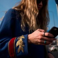 Woman looks at her mobile phone prior to the women's Fall/Winter 2018/2019 collection fashion show by Gucci in Milan, on February 21, 2018. / AFP...