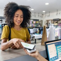 woman making a mobile payment at a clothing store - fashion stock pictures, royalty-free photos & images