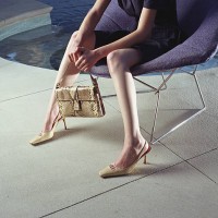 woman on chair holding handbag near pool - fashion photos et images de collection