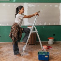 woman painting standing on a ladder - home decoration stock pictures, royalty-free photos & images