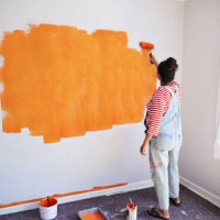 woman painting wall while renovating home - home decoration stockfoto's en -beelden