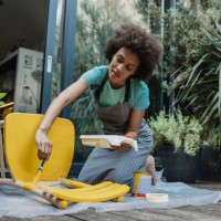 woman paints an old chair in the back yard - home decoration stock pictures, royalty-free photos & images