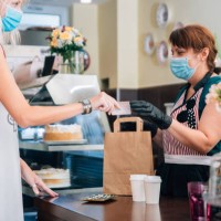 woman paying for takeaway food bag and a coffee cups during covid-19 - junk food stock pictures, royalty-free photos & images