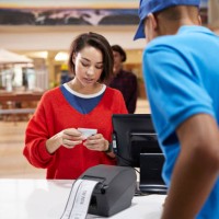 woman paying through credit card at ticket counter - junk food stock pictures, royalty-free photos & images