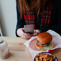 woman photographing a plate of junk food - junk food fotografías e imágenes de stock