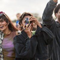 woman photographing against dancing friends - concert stock pictures, royalty-free photos & images