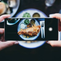 woman photographing fish and chips in a restaurant with a smartphone - food stock pictures, royalty-free photos & images