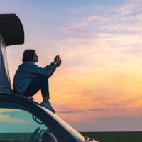 woman photographing the sunset from the rood of her campervan - travel stock pictures, royalty-free photos & images