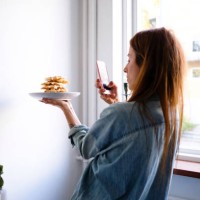 woman photographing waffles through smart phone in plate by wall at home - food stock pictures, royalty-free photos & images
