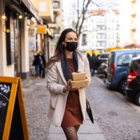 woman picking up her ordered food from a restaurant during pandemic - junk food stock pictures, royalty-free photos & images