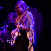 woman playing bass guitar onstage with band - concert stock pictures, royalty-free photos & images