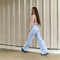 woman posing on move standing looking the camera and smiling in front of wall - fashion stock pictures, royalty-free photos & images