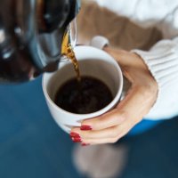 woman pouring herself hot coffee to a mug. - coffee stock pictures, royalty-free photos & images