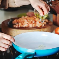 woman pouring olive oil into the skillet. - food stock pictures, royalty-free photos & images