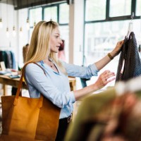 woman reading label on clothing while out shopping - fashion stock pictures, royalty-free photos & images