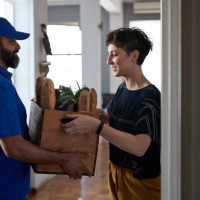 woman receiving groceries from delivery person - food stock pictures, royalty-free photos & images