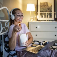 woman relaxing in bed and eating pasta - junk food stock pictures, royalty-free photos & images