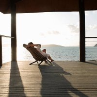 woman relaxing in deck chair on veranda. - travel stock pictures, royalty-free photos & images