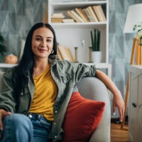 woman relaxing on a couch with a smile, front view. - home decoration stock pictures, royalty-free photos & images