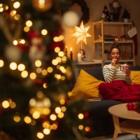 woman relaxing on sofa eating christmas candy cane at home - home decoration stock pictures, royalty-free photos & images