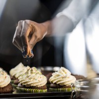 woman's hand sprinkling hundreds and thousands on cupcake - home decoration stock pictures, royalty-free photos & images