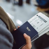 woman’s hands holding passports & boarding passes of her family while waiting at the check-in counter in the airport - travel stock pictures, royalty-free photos & images