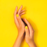 woman's hands with bright manicure are lying on yellow background. trendy colors of the year - nails art stock pictures, royalty-free photos & images