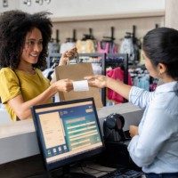 woman shopping at a clothing store and paying to the cashier - fashion stock pictures, royalty-free photos & images