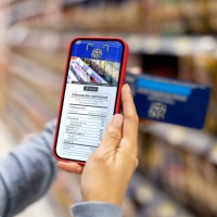 woman shopping at the supermarket and scanning a label with her cell phone - food stock pictures, royalty-free photos & images