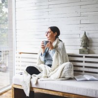 woman sitting comfortable and looking through the window - home decoration stock pictures, royalty-free photos & images